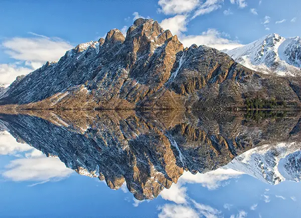 mountains reflecting in a sea